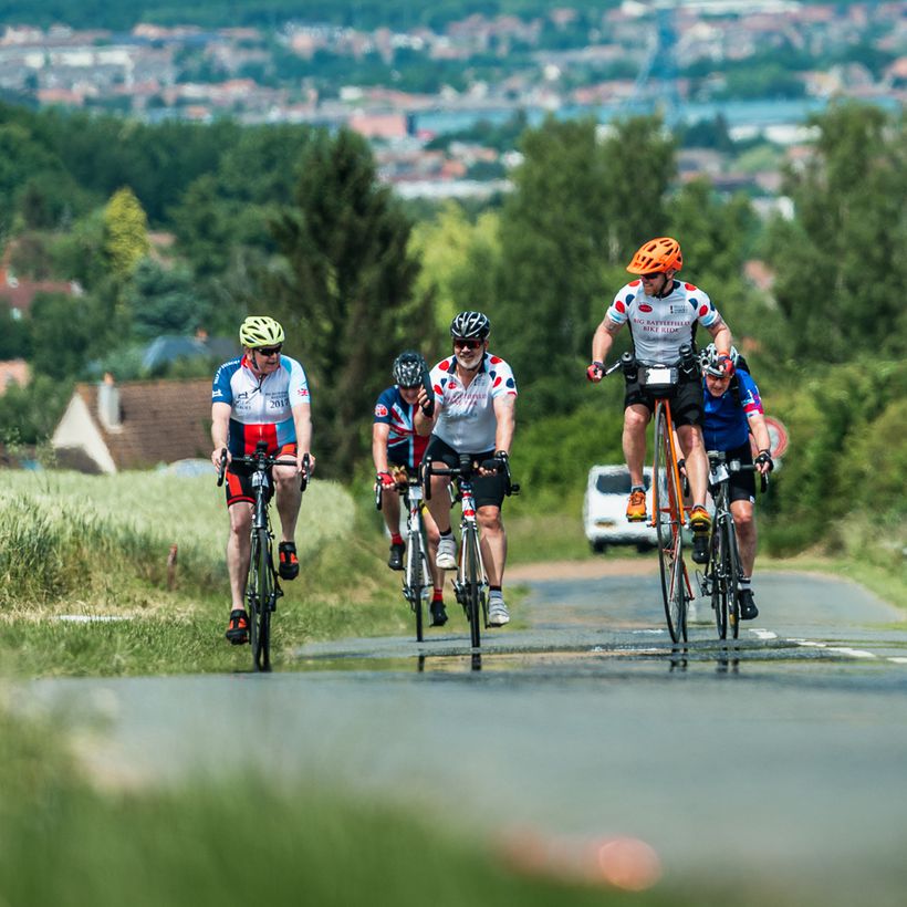 Cyclists riding in a group in the French countryside.