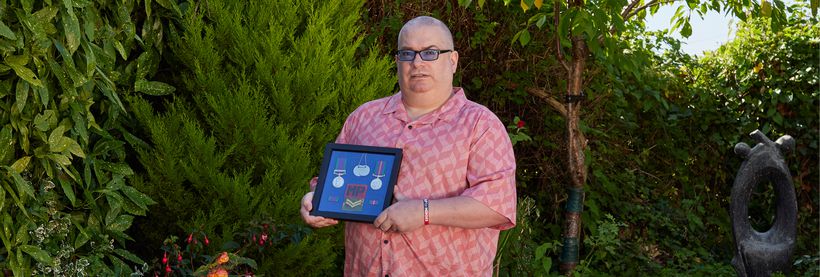 Veteran Paul holds up his medals from service